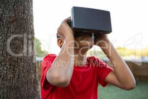 Elementary boy using virtual reality headset at park