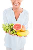 Cropped image of smiling mature woman holding fruits