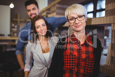 Confident business people standing by rack
