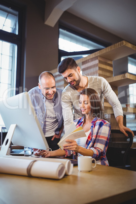 Businesswoman showing documents to male coworkers