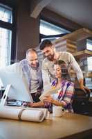 Businesswoman showing documents to male coworkers