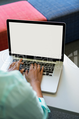 Cropped image of woman using laptop