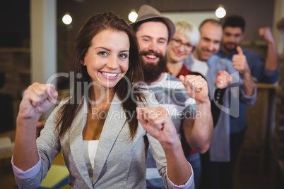 Coworkers cheering with clenched fist in creative office