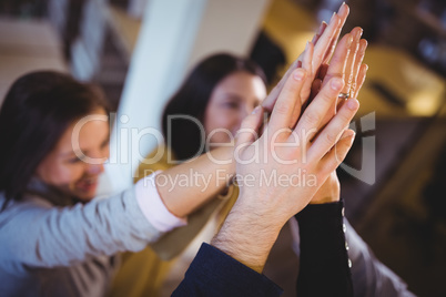 Creative business people high fiving in office