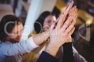 Creative business people high fiving in office