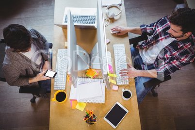 Male coworkers working at computer desk in creative office