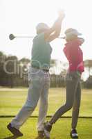 Mature male golf player teaching woman