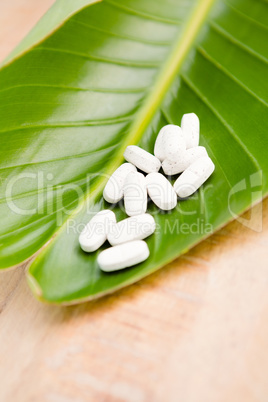 Close-up of pills on leaf at table