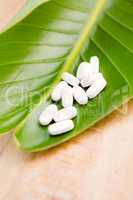 Close-up of pills on leaf at table