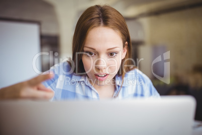 Surprised businesswoman working on laptop in office