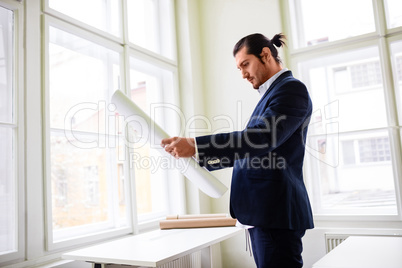 Confident architect holding blueprint