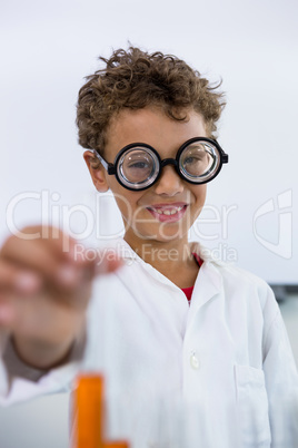 Boy showing test tube with liquid at laboratory