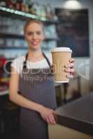Barista offering coffee cup at cafeteria