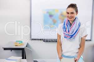 Portrait of teacher against whiteboard in classroom