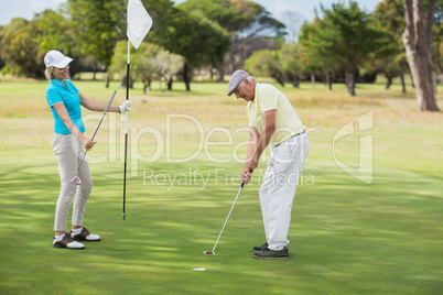 Mature man and woman playing golf