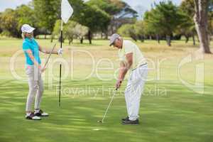 Mature man and woman playing golf