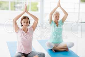 Women with hands clasped doing yoga