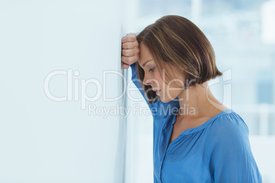 Side view of sad woman by wall