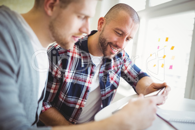 Close-up of happy businessmen using digital tablet in creative o