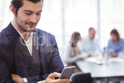 Businessman using smart phone in meeting room