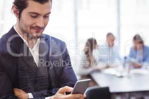 Businessman using smart phone in meeting room