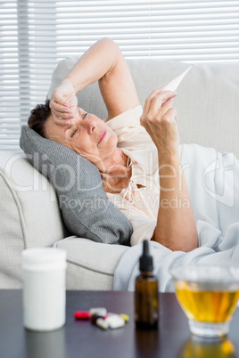 Mature woman holding thermometer