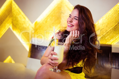 Happy woman enjoying drink in nightclub