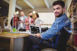 Smart disabled businessman using laptop at desk