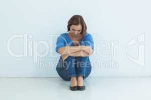 Sad woman sitting against wall
