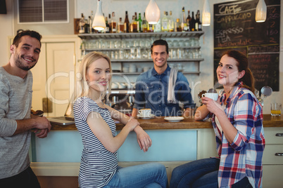 Portrait of waiter with happy customers at cafe