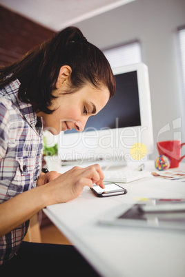 Woman using mobile phone on desk