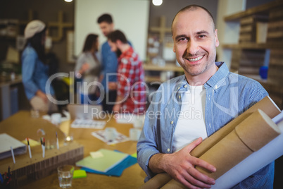 Architect with blueprints standing by table