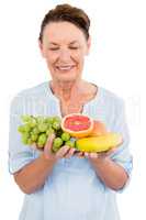 Happy mature woman holding fruits