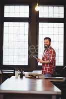 Happy hipster using tablet computer at desk