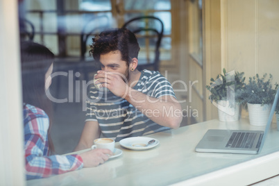 Woman talking to man at cafeteria