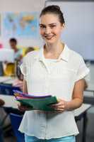 Teacher with files standing in classroom