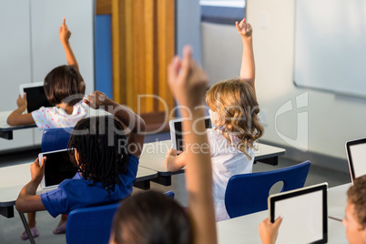 Children with digital tablets raising their hands