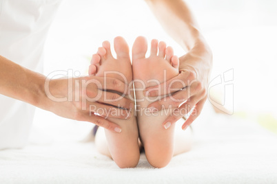 Cropped image of masseur giving foot massage to woman