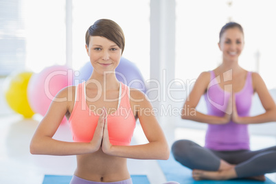 Smiling women exercising at fitness studio