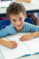 Boy writing on book