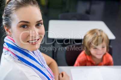 Young teacher with boy in classroom