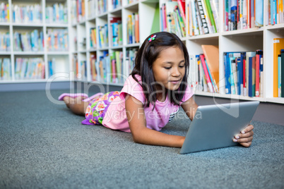 Girl using digital tablet in school library