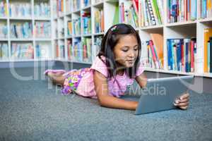 Girl using digital tablet in school library