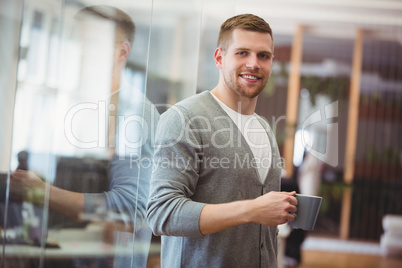 Businessman holding coffee cup in office