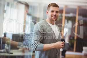 Businessman holding coffee cup in office