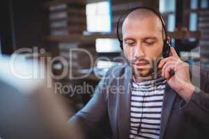 Businessman talking on headphones in creative office