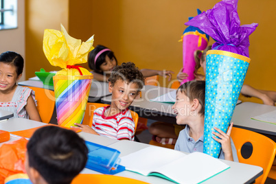 Cute children with craft work sitting on bench