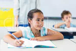 Smiling girl writing on book