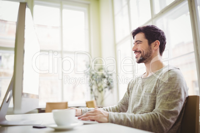 Confident businessman working on comuter in office