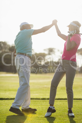 Full length of mature couple holding hands